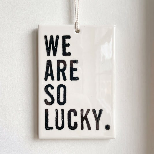 Porcelain wall tag: we
are
so
lucky.